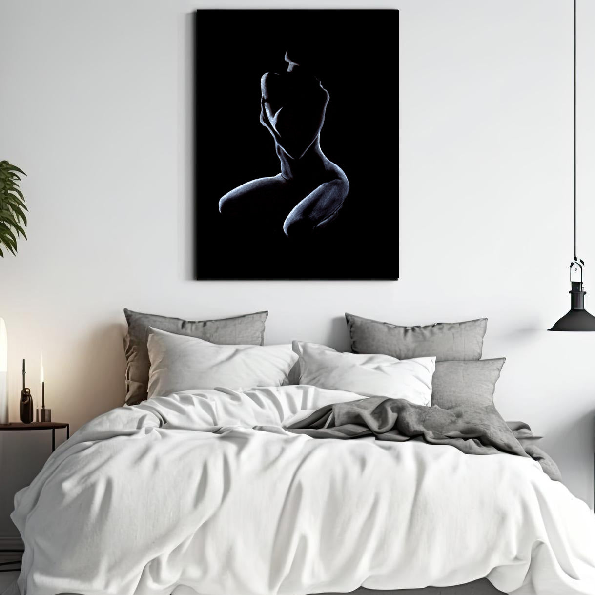 Graceful pastel figure drawing hangs on the wall above a white and gray bed in a modern bedroom. To the right side is a smaller figure artwork hanging above a side table with books on top. On the left of the artwork is a side table and tall plant.