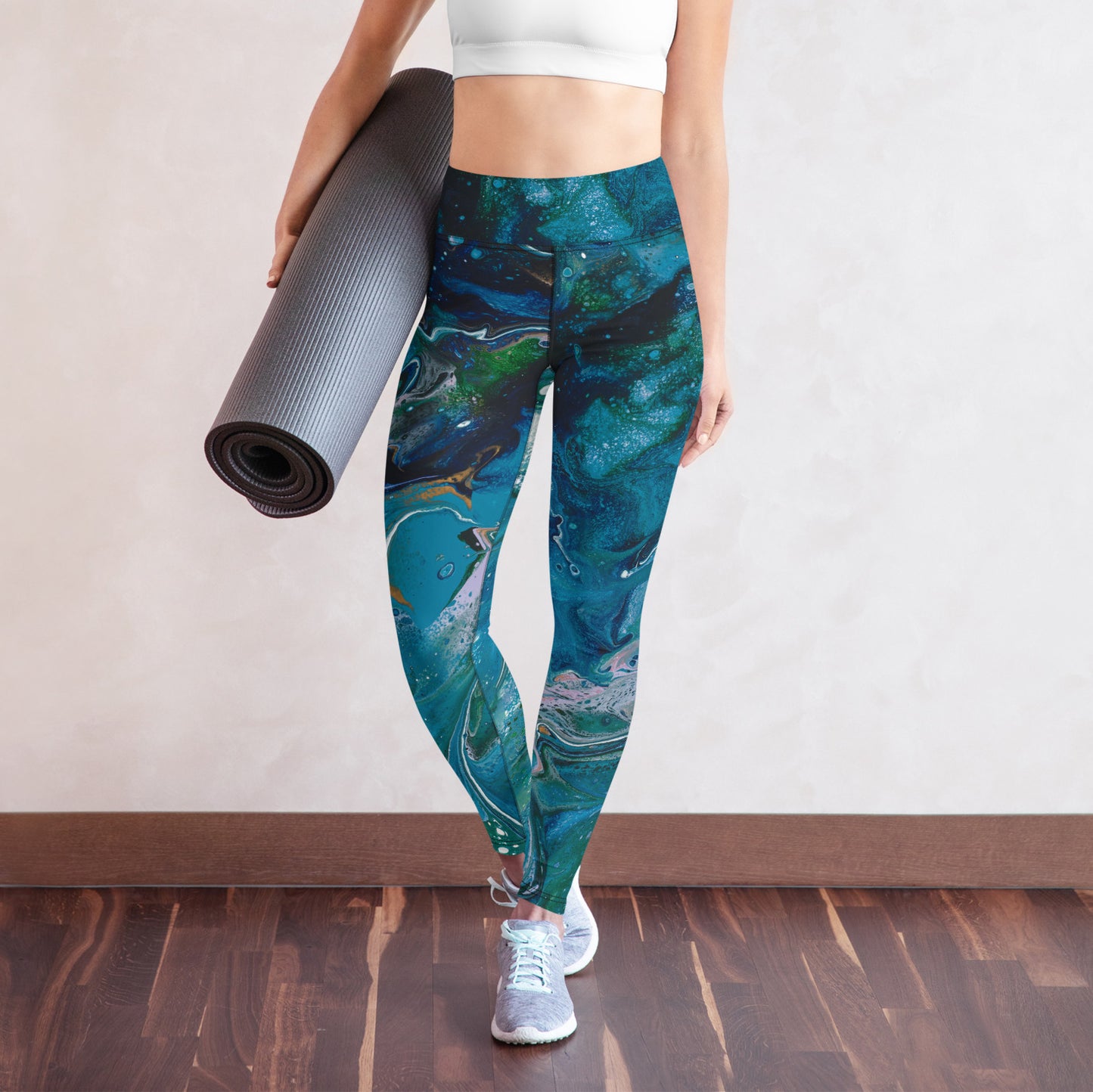 Model wearing activewear leggings and holding yoga mat. View of pants from the front.